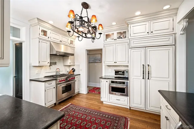 a kitchen with stainless steel appliances granite countertop a stove a refrigerator and a microwave
