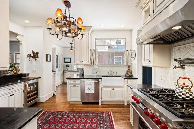 a kitchen with stainless steel appliances a stove a sink cabinets and a window