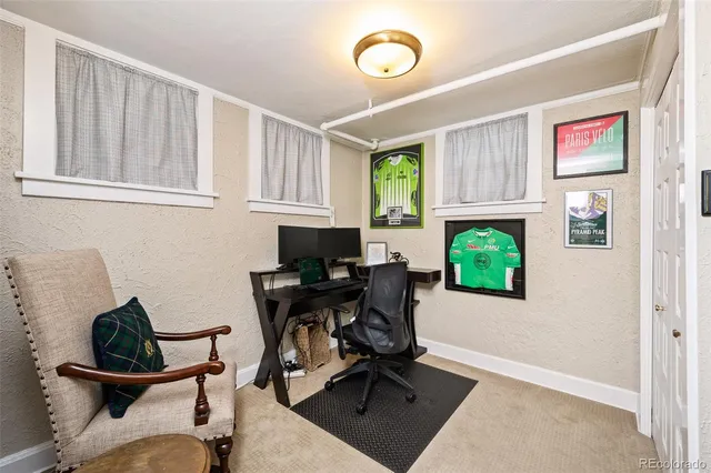 a view of a workspace with furniture and a window