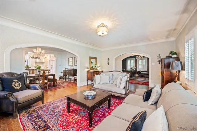 a living room with furniture a table and a chandelier