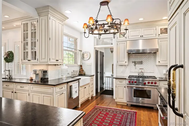 a kitchen with stainless steel appliances a stove a sink dishwasher a refrigerator and cabinets with wooden floor