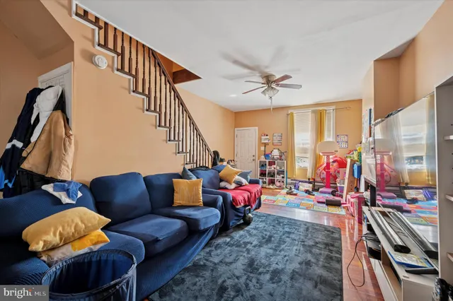 a living room with furniture a rug and white walls