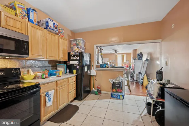 a view of a kitchen with fridge and workspace