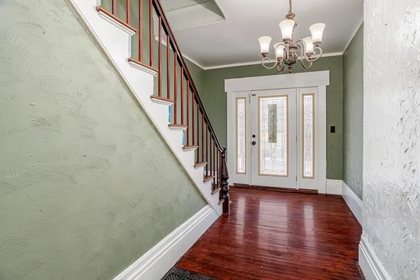 a view of a hallway with wooden floor and staircase