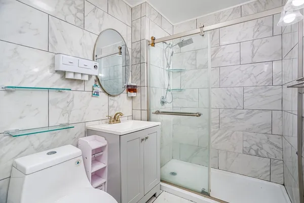 a bathroom with a sink a toilet and shower