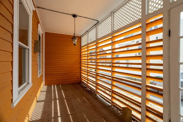 a view of a balcony with wooden floor and brick walls