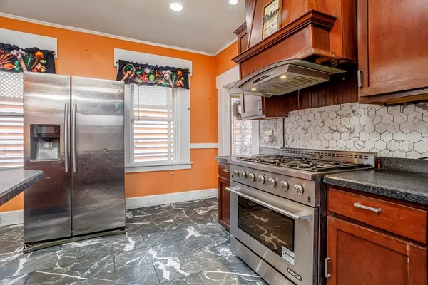 a kitchen with stainless steel appliances granite countertop a stove and a refrigerator