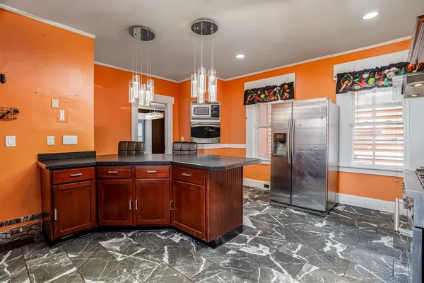 a large kitchen with stainless steel appliances granite countertop a refrigerator and a sink