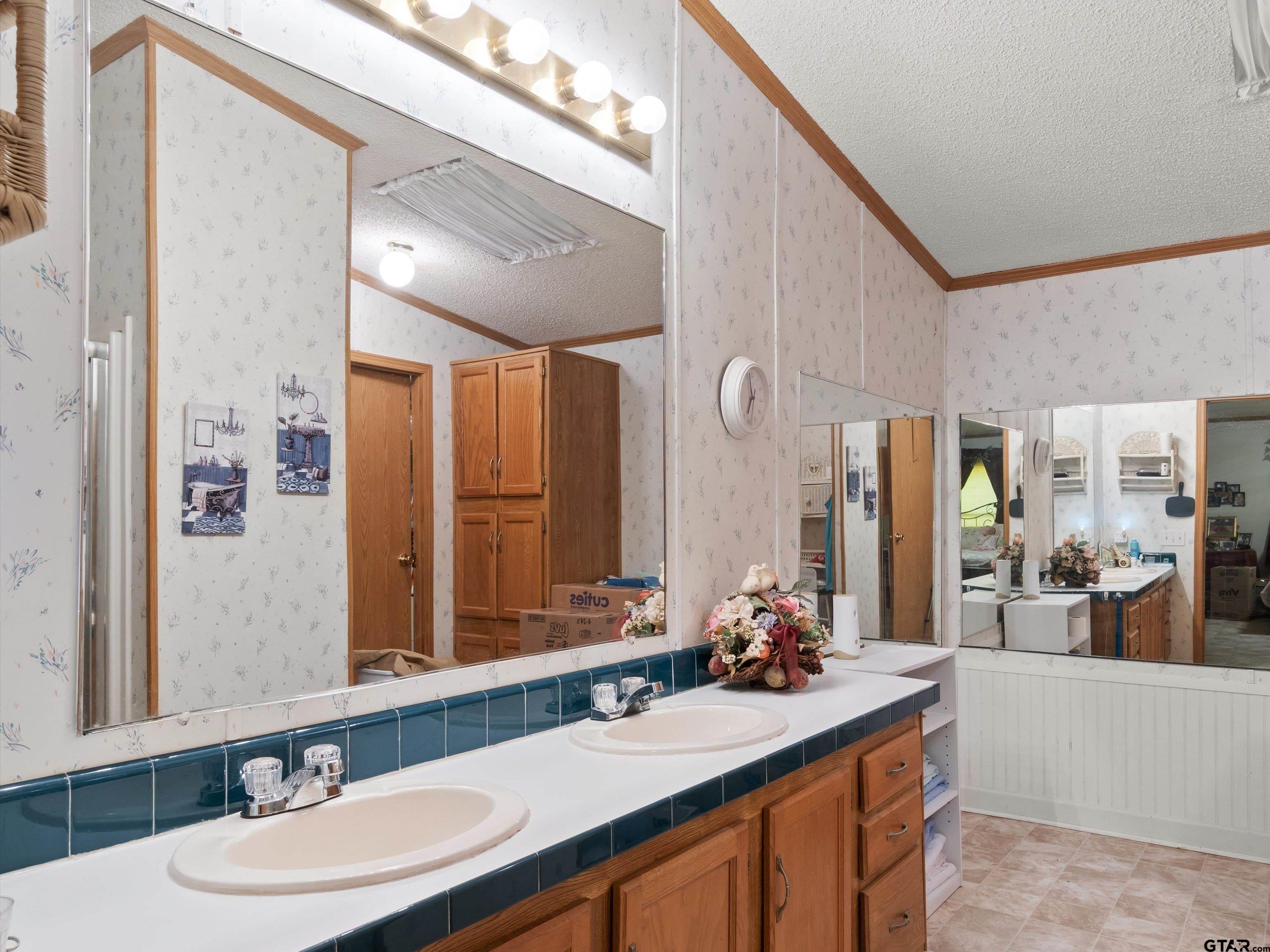 2811 Medlin Road Gilmer, TX 75645 - Photo 26 of 30 a bathroom with a sink double vanity granite and a mirror