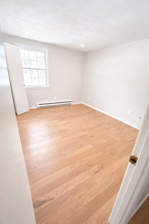 369 Berlin Road Marlborough, MA 01752 - Photo 4 of 12 an empty room with wooden floor and windows