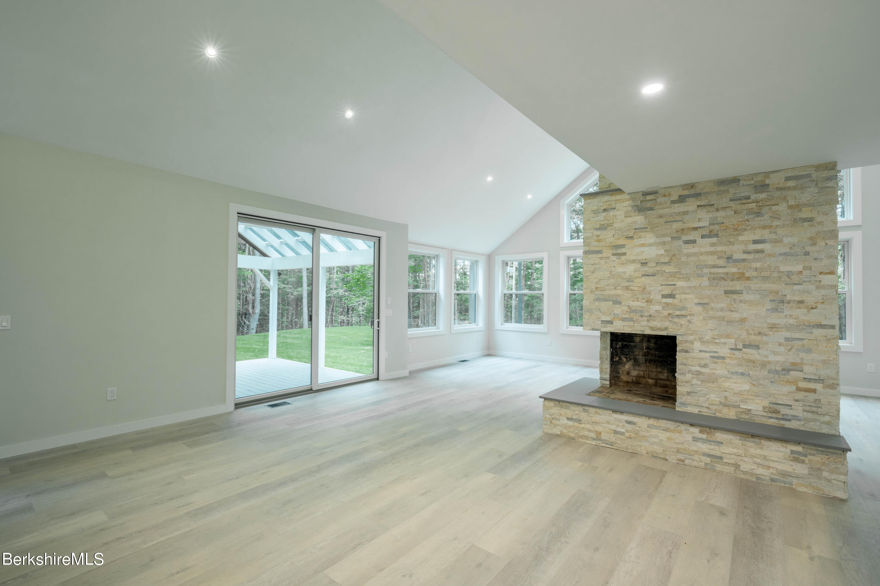 220 Hupi Road Monterey, MA 01245 - Photo 18 of 38 a view of an empty room with a fireplace and a window