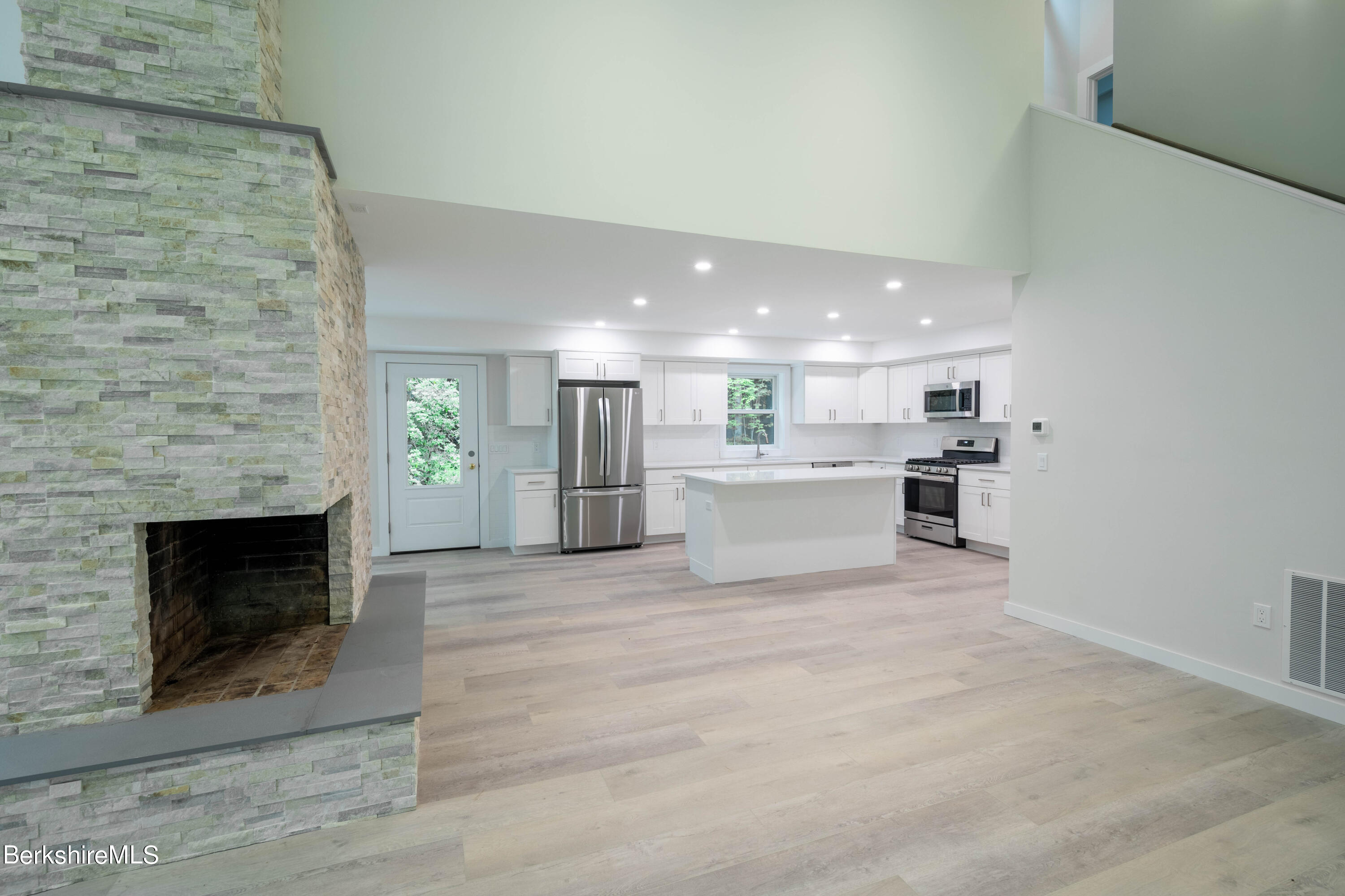 220 Hupi Road Monterey, MA 01245 - Photo 20 of 38 a view of kitchen with kitchen island a fireplace wooden floor and living room view