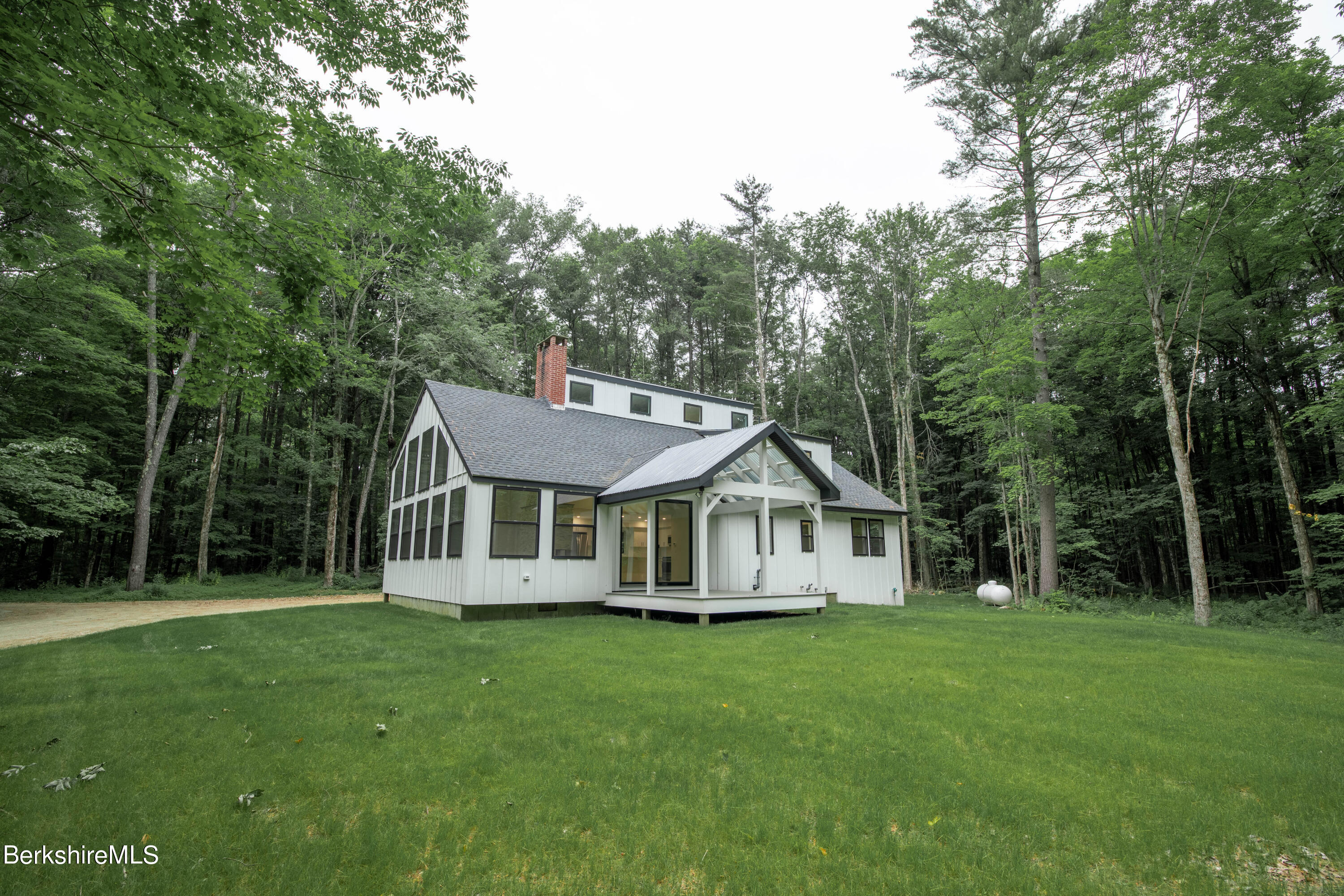 220 Hupi Road Monterey, MA 01245 - Photo 2 of 38 a view of a white house with a big yard and large trees