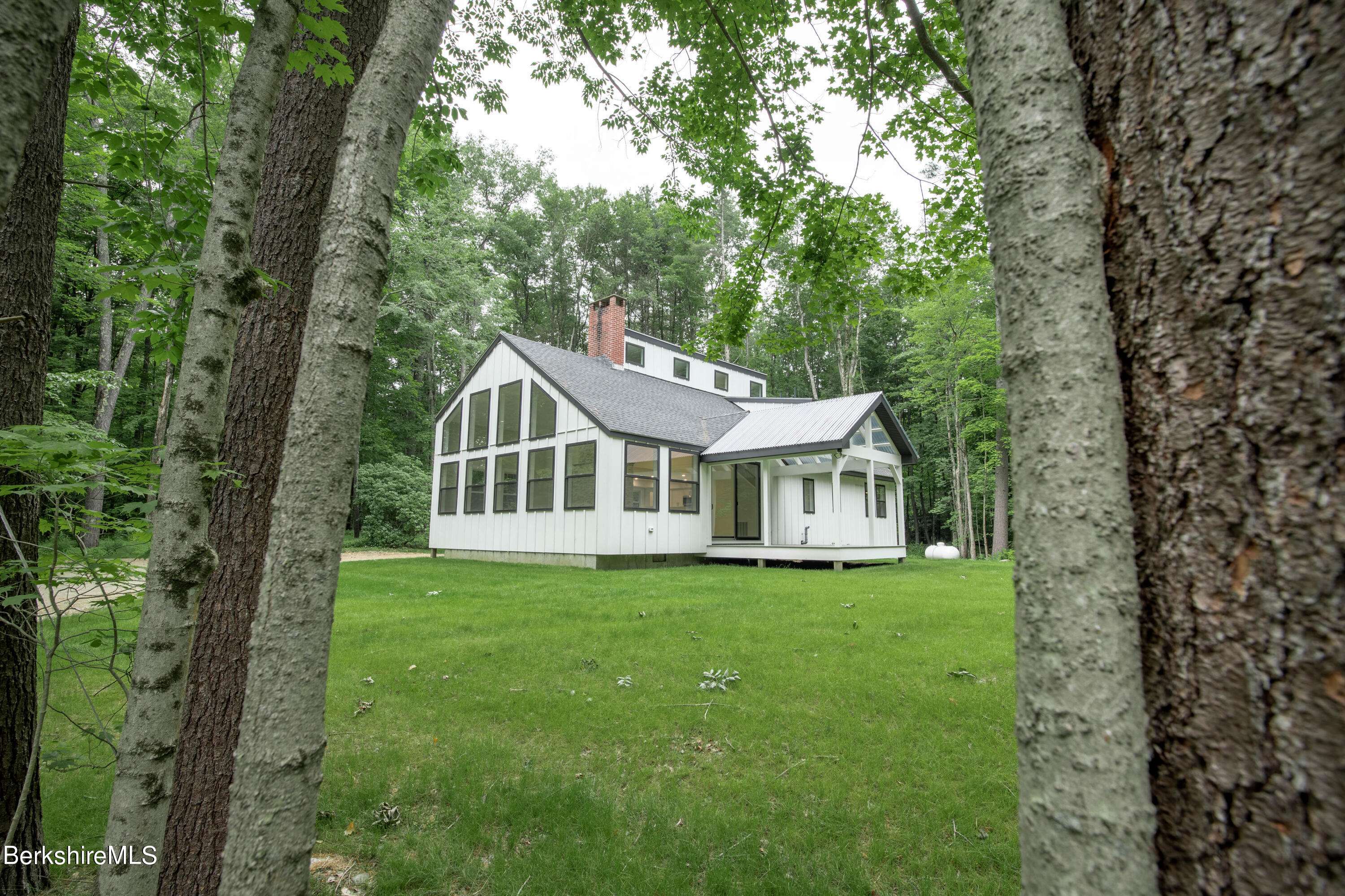 220 Hupi Road Monterey, MA 01245 - Photo 6 of 38 a white house that has a tree in front of the house