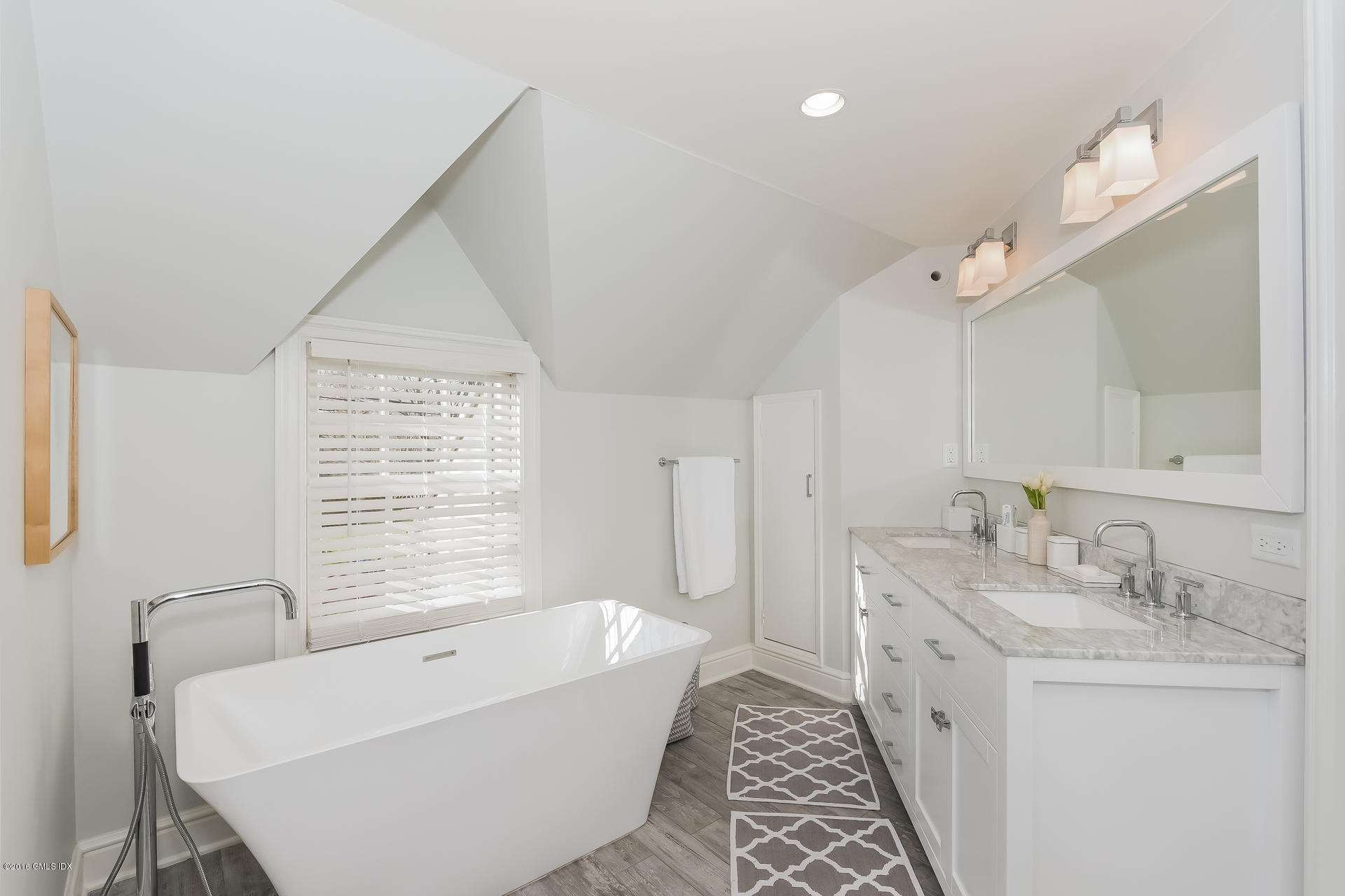 122 Hollow Tree Ridge Road Darien, CT 06820 - Photo 34 of 49 a bathroom with a tub sink and mirror