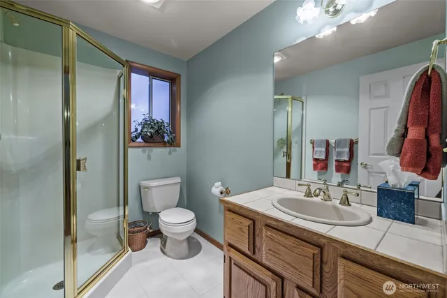 a bathroom with a sink a toilet and a large mirror