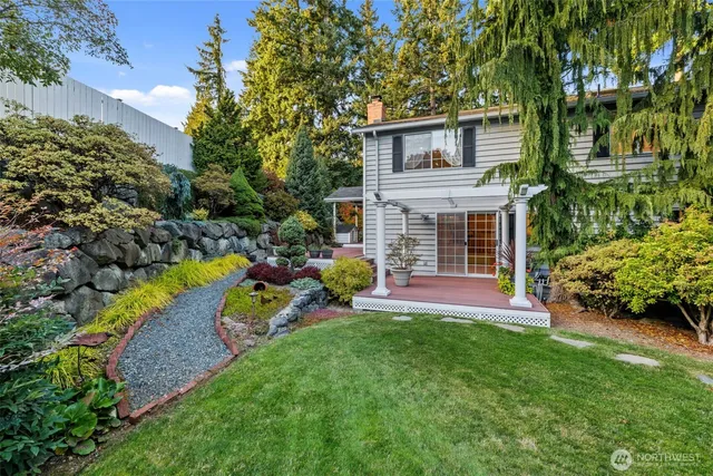 a view of a yard with plants and a bench