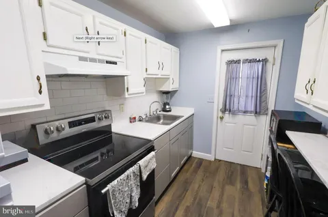 a kitchen with stainless steel appliances a sink dishwasher stove and cabinets