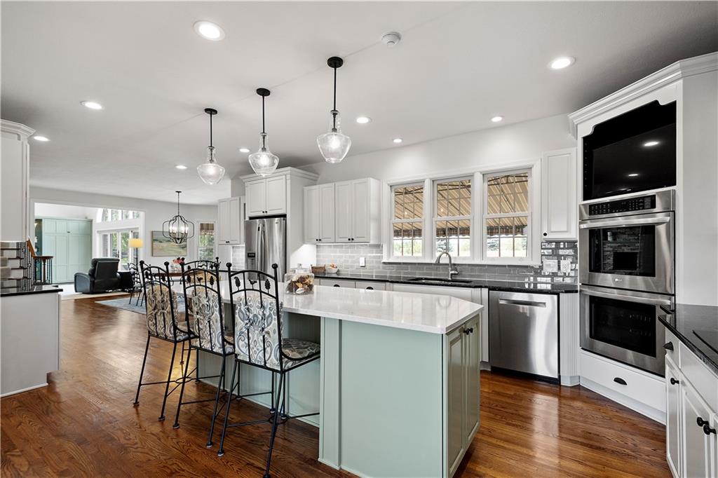 3012 East Ridge Drive Gibsonia, PA 15044 - Photo 11 of 50 a kitchen with stainless steel appliances granite countertop a stove top oven a sink dishwasher a dining table and chairs with wooden floor