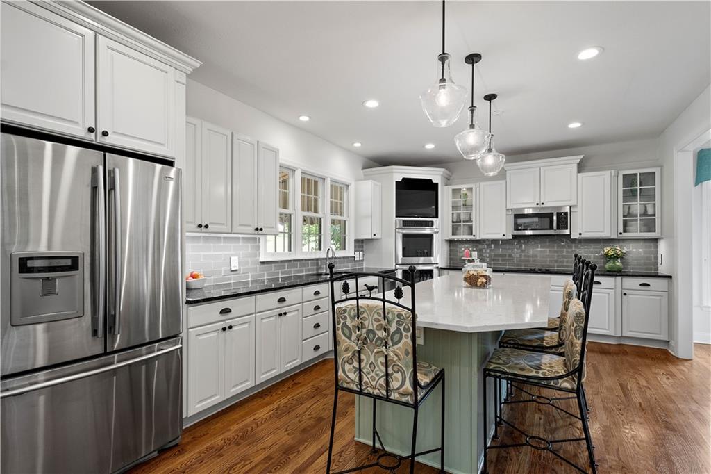 3012 East Ridge Drive Gibsonia, PA 15044 - Photo 14 of 50 a kitchen with stainless steel appliances granite countertop a refrigerator a stove a sink a dining table and chairs with wooden floor