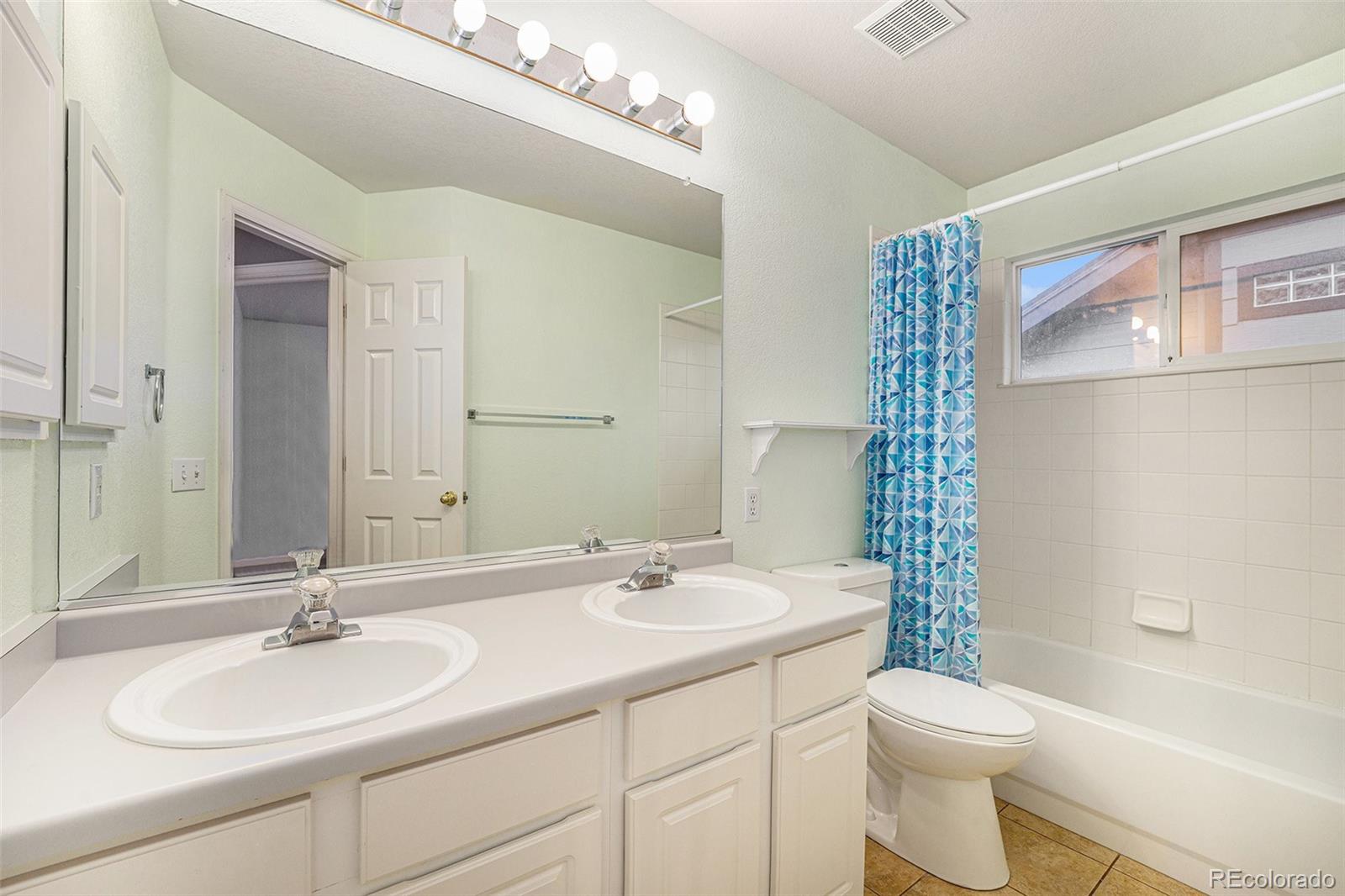 9705 Carr Circle Westminster, CO 80021 - Photo 31 of 43 a bathroom with a double vanity sink toilet and a mirror