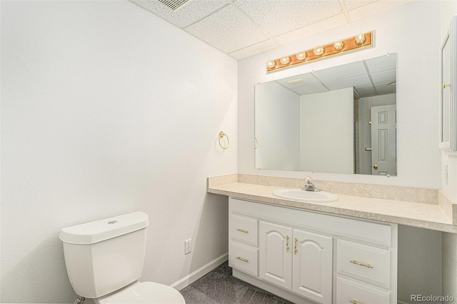 9705 Carr Circle Westminster, CO 80021 - Photo 35 of 43 a bathroom with a toilet sink and mirror