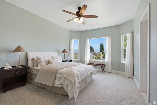 1252 Skyline Road Saratoga Springs, UT 84045 - Photo 17 of 51 Spacious bedroom featuring light blue walls, soft grey carpeting, a multi-pane window with a deep sill, and a ceiling fan with integrated lighting