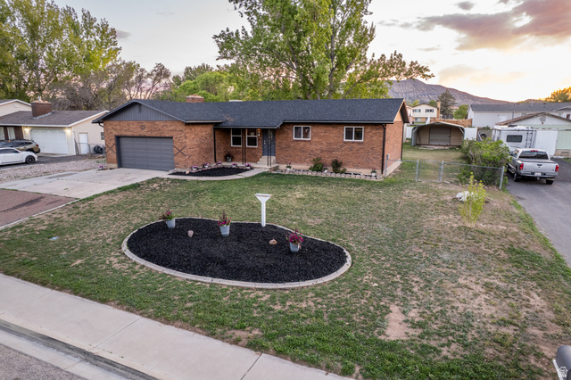 634 South 2100th Street West Vernal, UT 84078 - Photo 69 of 71 Brick exterior residence with a dark shingle roof and an integrated single-car garage