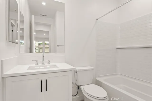 a bathroom with a sink toilet vanity and shower