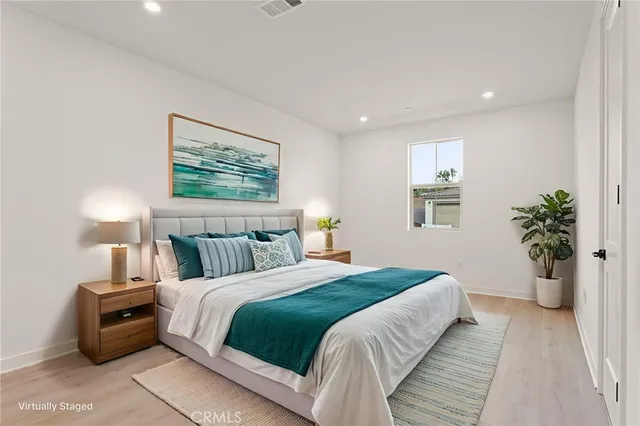 a bedroom with a large bed and a potted plant