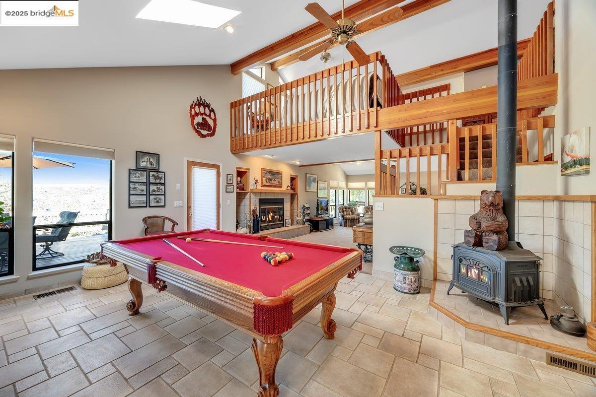 13700 Clements Road Groveland, CA 95321 - Photo 40 of 93 Recreation room with ceiling fan, high vaulted ceiling, a wood stove, pool table, and beamed ceiling