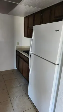 a white refrigerator freezer and a stove sitting inside of a kitchen