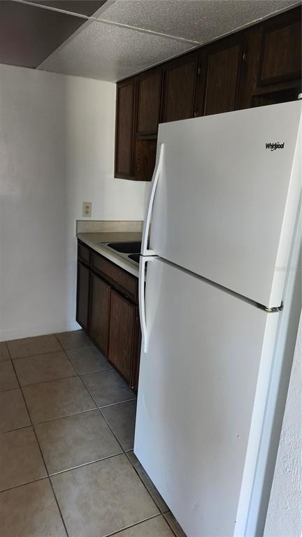 1216 Kennedy Road, Unit 10 Daytona Beach, FL 32117 - Photo 5 of 14 a white refrigerator freezer and a stove sitting inside of a kitchen