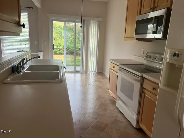 a kitchen with granite countertop a sink and a stove top oven