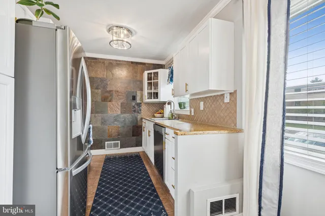 a bathroom with a granite countertop double vanity and a shower