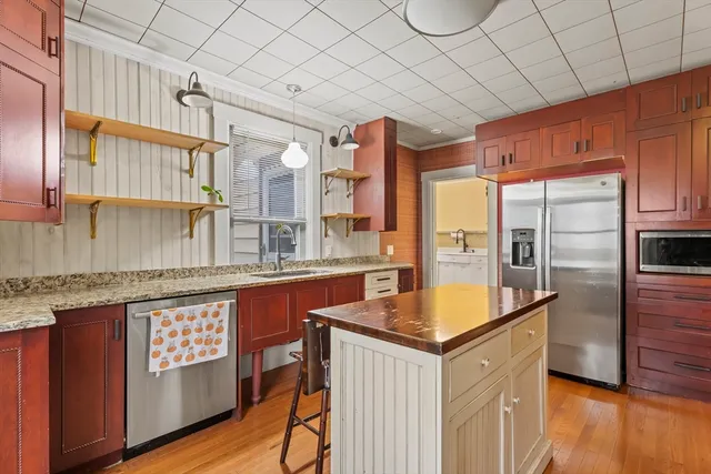 a kitchen with stainless steel appliances granite countertop a sink a stove and a refrigerator