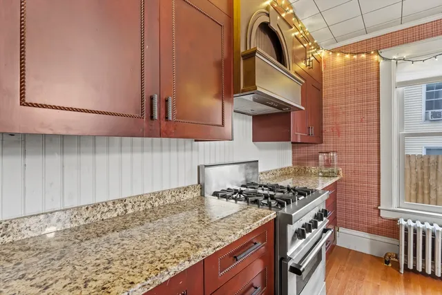 a kitchen with granite countertop a stove a sink and a microwave