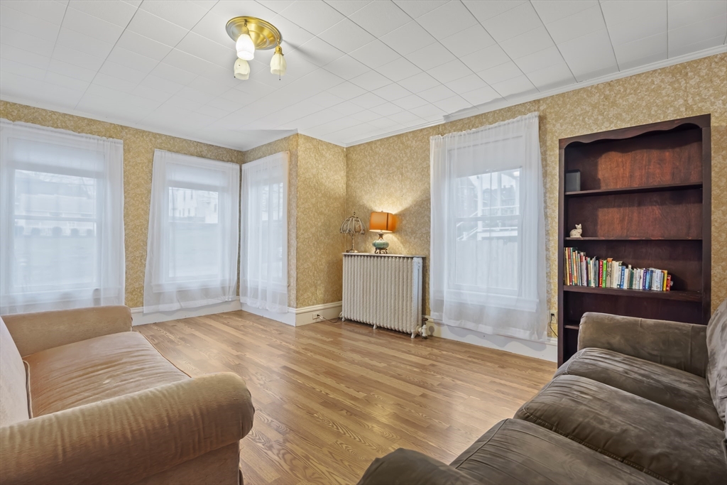 216 Walnut Street Clinton, MA 01510 - Photo 19 of 40 a living room with furniture and a chandelier