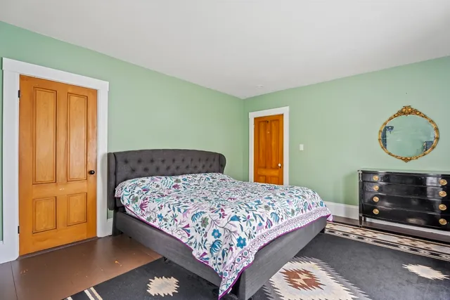 a bedroom with a bed a dresser and a window