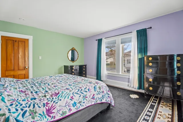 a bedroom with a bed dresser and a window