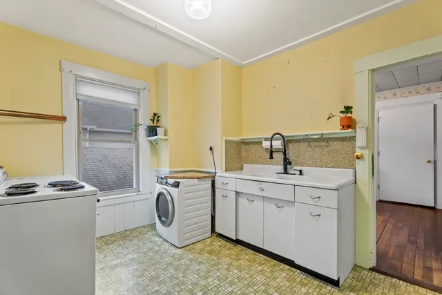 a kitchen with sink a refrigerator and cabinets