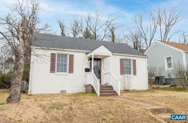 a view of a white house with a large tree in front of it
