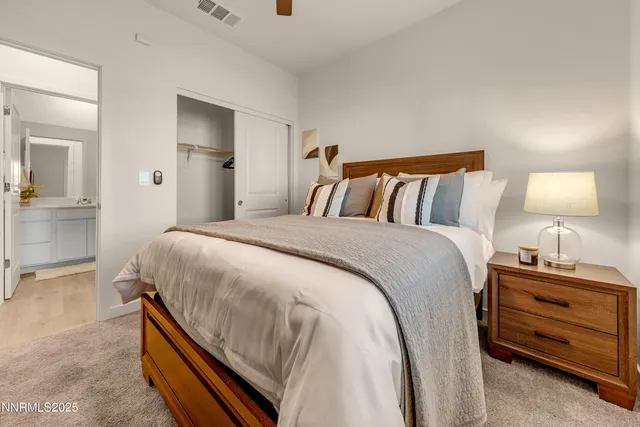 a bedroom with a bed and a lamp on dresser