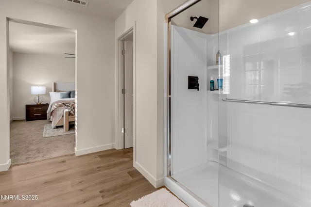 a bathroom with a tub shower and a mirror