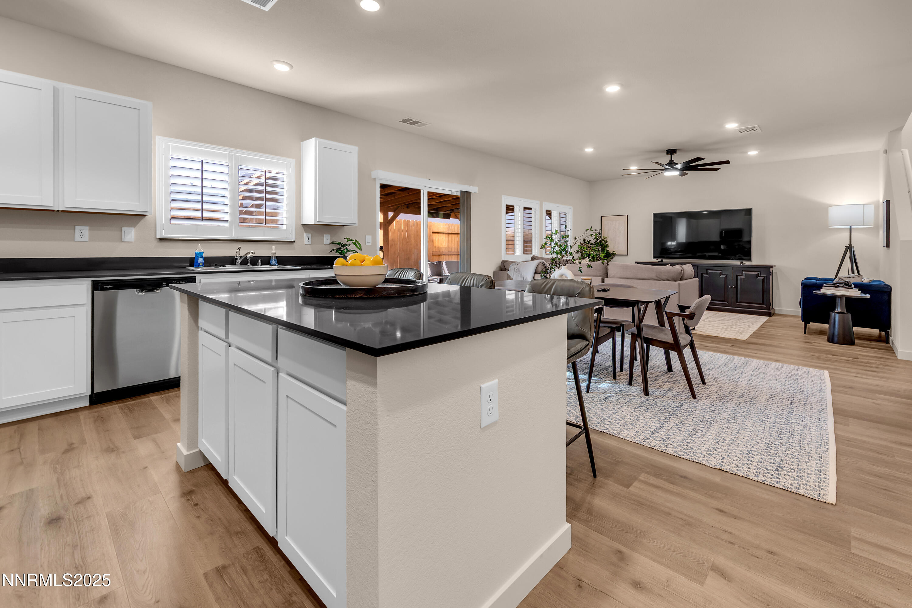 7754 Wandering Way Reno, NV 89506 - Photo 10 of 37 a kitchen with stainless steel appliances granite countertop a stove top oven a sink dishwasher a dining table and chairs with wooden floor
