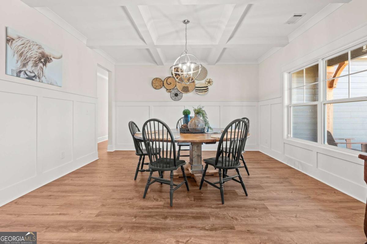 1515 Pleasant Ridge Road Carrollton, GA 30117 - Photo 11 of 72 a dining room with wooden floor a chandelier a wooden table and chairs