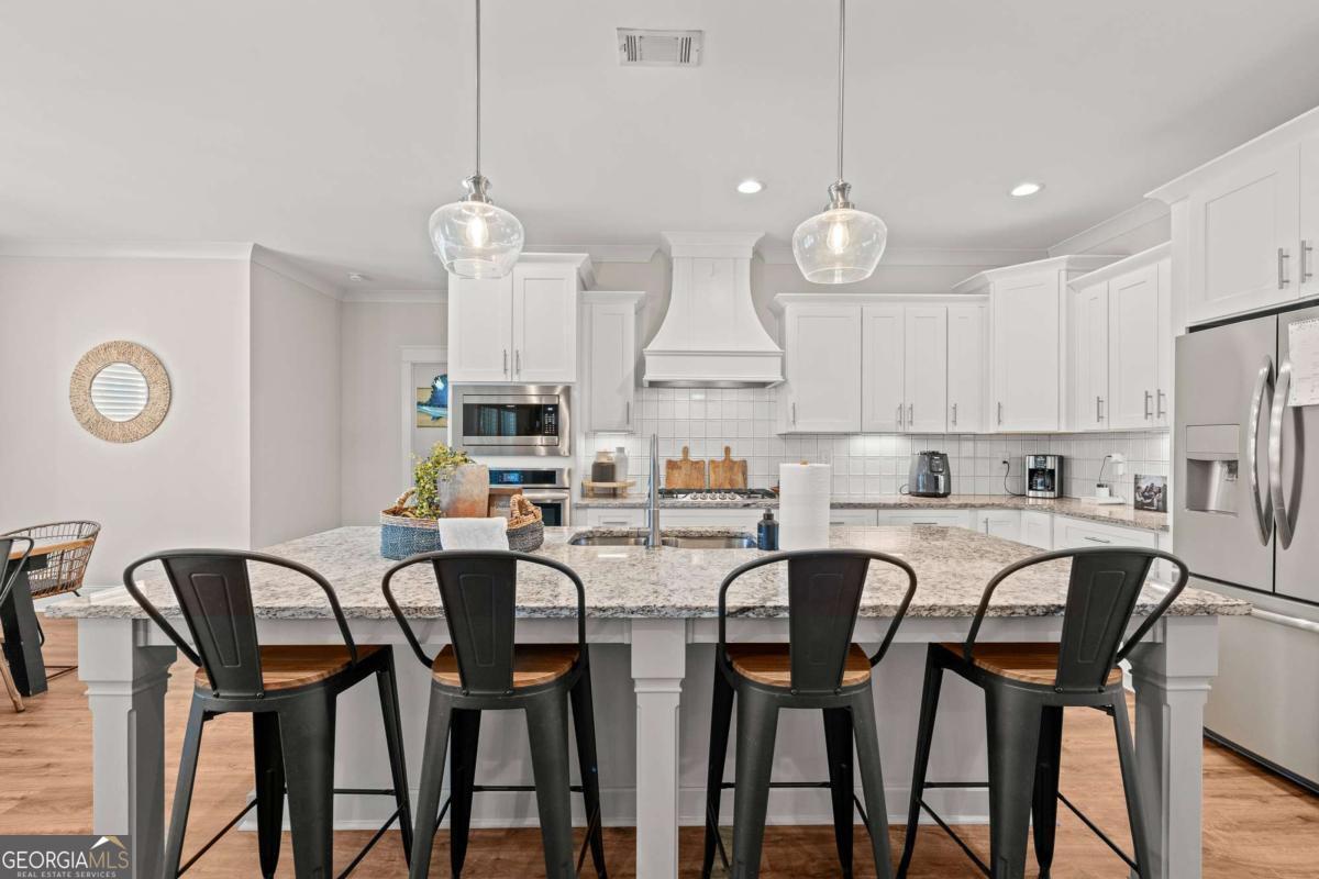 1515 Pleasant Ridge Road Carrollton, GA 30117 - Photo 19 of 72 a large kitchen with a dining table chairs sink and white cabinets