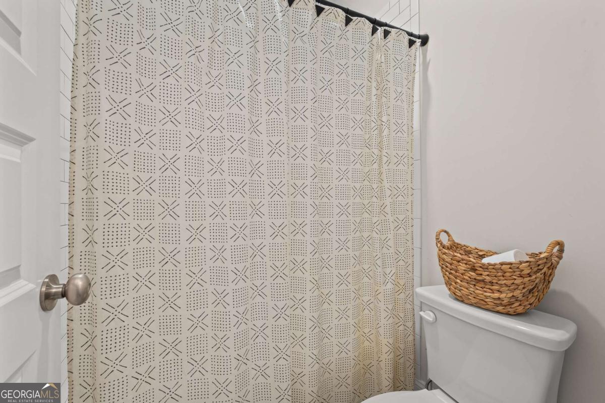 1515 Pleasant Ridge Road Carrollton, GA 30117 - Photo 33 of 72 a bathroom with a toilet and a shower curtain
