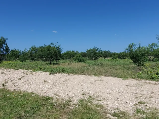 a view of a dirt road with a building in the background