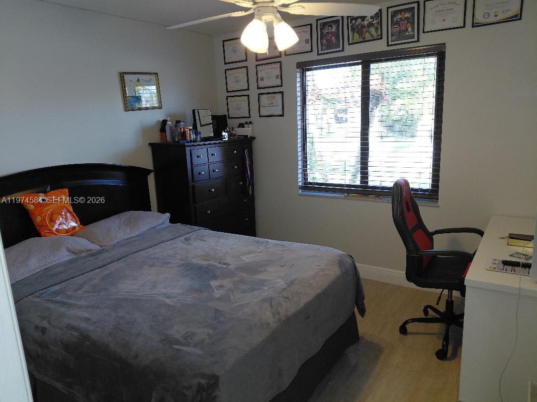 15630 Southwest 146th Avenue Miami, FL 33177 - Photo 19 of 23 a bedroom with a bed and a chandelier